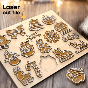 May include: A wooden sheet with 16 laser cut Christmas ornament designs. The designs include a bell, a snowflake, a candy cane, a mitten, a snowman, a reindeer, a Santa Claus, a Christmas tree, a stocking, a bow, a gingerbread house, a hot beverage mug, a snow globe, a pair of ice skates, a sleigh, and the text "Merry Christmas".