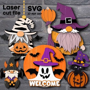 Puede incluir: Un conjunto de cinco decoraciones de gnomos y fantasmas con temática de Halloween. Las decoraciones están hechas de madera y presentan una variedad de colores, incluyendo naranja, morado, negro y blanco. Las decoraciones incluyen un gnomo sosteniendo una calabaza, un gnomo con una escoba, un fantasma con alas, un gnomo con un caldero y un gato negro sentado en una calabaza. Las decoraciones son perfectas para agregar un toque festivo a tu hogar durante la temporada de Halloween.