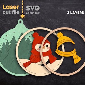 May include: A three-layer laser cut file design featuring a light green ornament shape with a forest scene, a middle layer with a red bird wearing a red hat and scarf, and a top layer with a yellow hat and scarf. Text reads Laser cut file SVG AI PDF DXF 3 LAYERS.