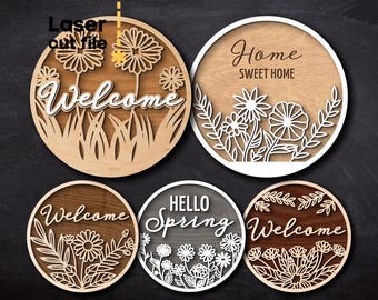 May include: Five wooden round signs with laser cut floral designs and text. The signs read "Welcome", "Home Sweet Home", "Hello Spring", and "Welcome".