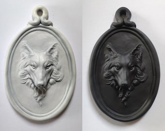 Wall portrait of a wolf, in the shape of a medallion, plaster sculpture