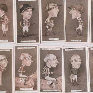 Puede incluir: Una colección de tarjetas de caricaturas de carreras de Player's Cigarettes vintage. Cada tarjeta presenta una ilustración de dibujos animados de un jockey con atuendo de carreras. Las tarjetas están en tonos sepia, con texto en la parte superior de cada tarjeta.