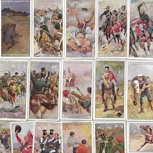 May include: A collection of vintage Players Cigarettes cards, each featuring a detailed illustration of historical military scenes. The cards depict soldiers in various uniforms, horses, and battle scenarios, with text at the top.