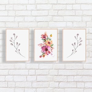 Puede incluir: Tres impresiones de acuarela enmarcadas con dise&ntilde;os florales y de ramas. La impresi&oacute;n central presenta un ramo de flores rosas, naranjas y amarillas con hojas verdes. Las impresiones de la izquierda y la derecha presentan ramas grises simples con peque&ntilde;os brotes grises.