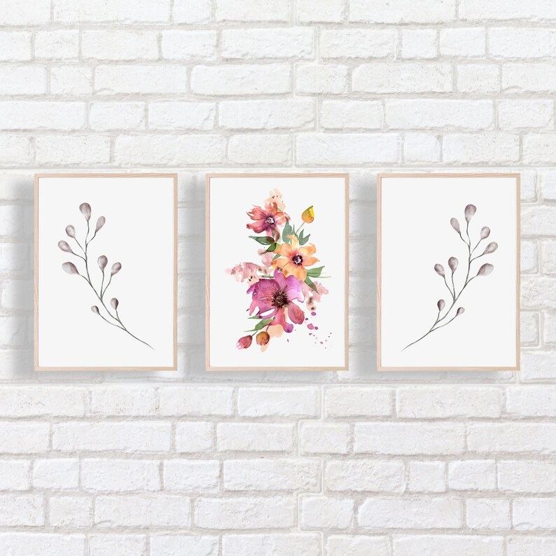 Puede incluir: Tres impresiones de acuarela enmarcadas con dise&ntilde;os florales y de ramas. La impresi&oacute;n central presenta un ramo de flores rosas, naranjas y amarillas con hojas verdes. Las impresiones de la izquierda y la derecha presentan ramas grises simples con peque&ntilde;os brotes grises.