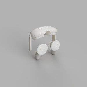 May include: A white plastic nasal dilator, designed to open nasal passages. The device features a curved bridge with three small bumps and two circular pads with raised dots. The dilator is shown against a gray background.