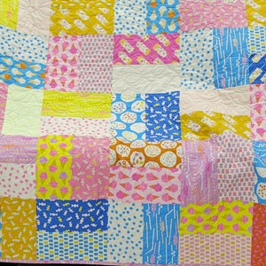 Pu&ograve; includere: Una colorata trapunta patchwork con vari quadrati a fantasia. La trapunta presenta coni gelato, caramelle e pois nei toni del rosa, giallo, blu e arancione. &Egrave; un articolo fatto a mano e accogliente.