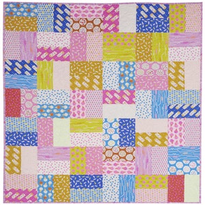 Pu&ograve; includere: Una colorata trapunta patchwork con vari motivi di coni gelato, ghiaccioli e zuccherini nei toni del rosa, blu, giallo e oro. La trapunta &egrave; composta da blocchi rettangolari e ha un bordo rosa.