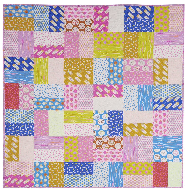 Pu&ograve; includere: Una colorata trapunta patchwork con vari motivi di coni gelato, ghiaccioli e zuccherini nei toni del rosa, blu, giallo e oro. La trapunta &egrave; composta da blocchi rettangolari e ha un bordo rosa.