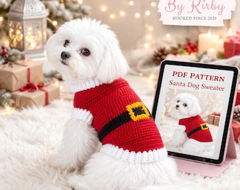 May include: A white dog wearing a red and white crocheted Santa-style sweater with a black belt and gold buckle. A tablet displays a PDF pattern for the sweater. The image includes the text "Crochet By Kirby" and "Hooked Since 2020".