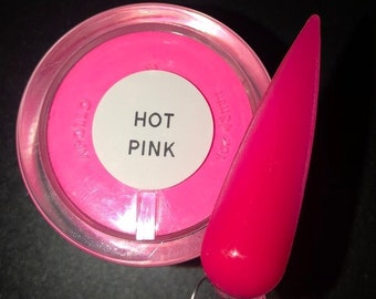 Puede incluir: Un pequeño frasco de polvo acrílico rosa intenso con una etiqueta blanca que dice "HOT PINK". Se muestra una punta de uña rosa intenso junto al frasco.