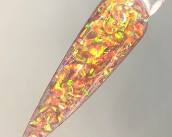 以下が含まれることがあります： 虹色の金色のグリッターで満たされた透明なネイルポリッシュボトル