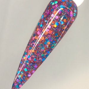 Könnte beinhalten: Nahaufnahme einer Nagellackflasche mit einem mehrfarbigen Glitzerfinish. Der Glitzer ist eine Mischung aus irisierendem Blau, Grün, Lila und Orange.