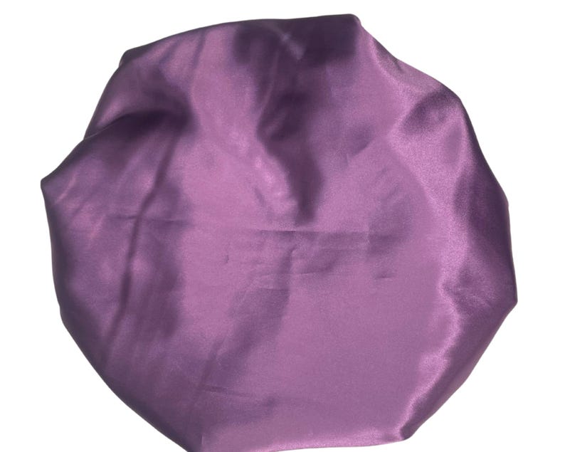 Op de afbeelding: Een paarse satijnen slaapmuts om het haar te beschermen tijdens het slapen.