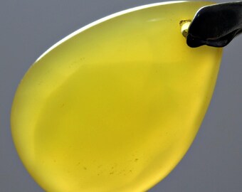 May include: A teardrop-shaped pendant made of yellow chalcedony, with a silver bail.