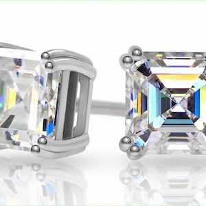 May include: A pair of silver stud earrings with square-shaped clear gemstones.