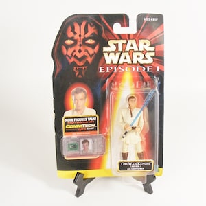 May include: Star Wars Episode 1 Obi-Wan Kenobi action figure with a blue lightsaber, packaged on a card with Darth Maul's image. The package includes a CommTech chip. Ages 4 & Up.
