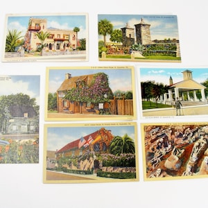 May include: A collection of vintage postcards featuring colorful illustrations of buildings and landmarks. The postcards showcase various architectural styles and scenes, including a historic schoolhouse and a coastal fort.