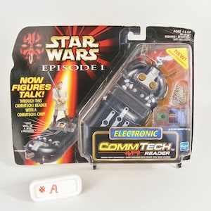 May include: A black and silver Star Wars Episode I CommTech Reader toy. The reader is used to make action figures talk. The packaging features a red lightsaber and a Darth Maul character.