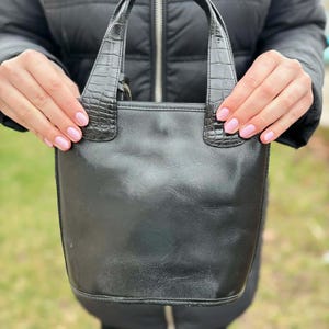 May include: A set of three ceramic mugs with a speckled, matte finish. The mugs are in shades of cream, light gray, and dark gray. Each mug has a simple, minimalist design and a rounded handle.