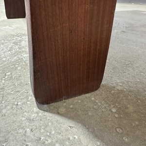 May include: Close-up of the bottom of a dark brown wooden table leg.