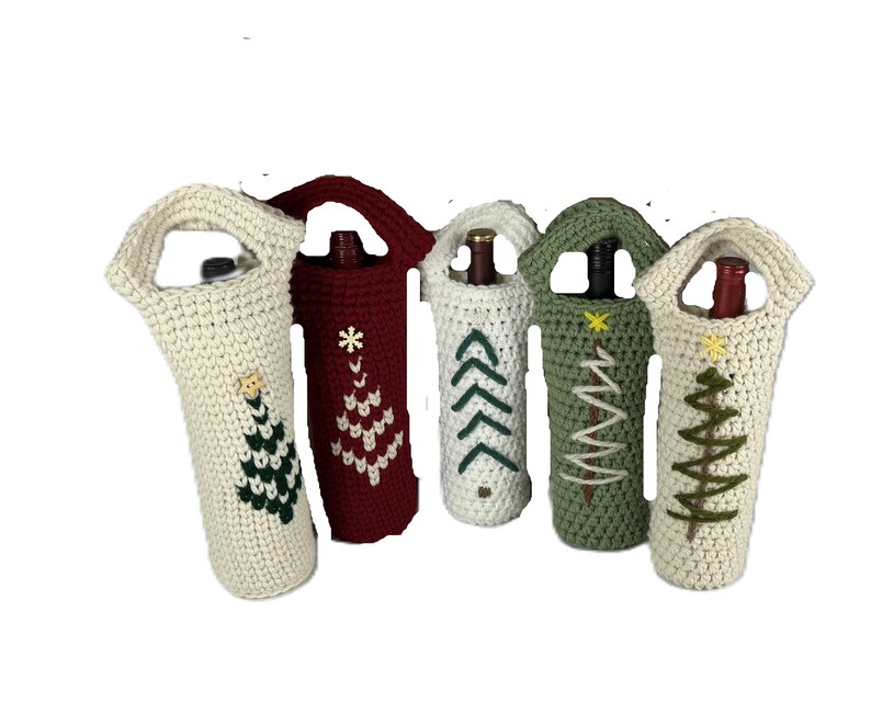 Pu&ograve; includere: Cinque copribottiglie all'uncinetto con manici, ognuno caratterizzato da un disegno di albero di Natale ricamato. Le coperture sono color crema, rosso scuro e verde salvia, con dettagli a stella ricamati su alcuni alberi. Ogni custodia contiene una bottiglia.