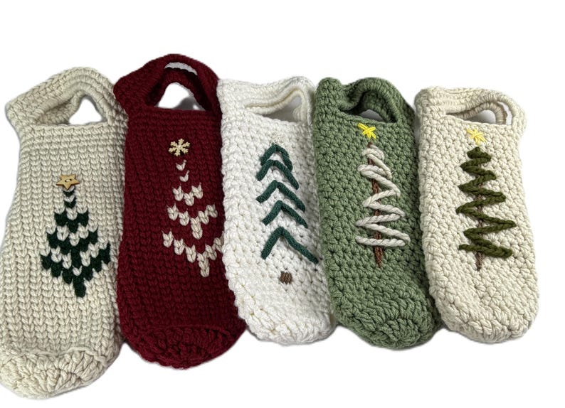 Pu&ograve; includere: Cinque borse per bottiglie realizzate a mano all'uncinetto con manici, caratterizzate da vari disegni di alberi di Natale. Le borse sono nei colori crema, bordeaux, bianco e verde salvia, con motivi ad albero ricamati e stelle in legno.