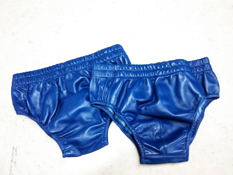 May include: Two pairs of blue shiny athletic shorts with elastic waistbands.