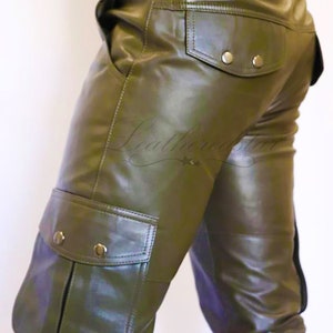 May include: Olive green leather cargo pants with a brown leather belt. The pants have a large cargo pocket on the left leg and a smaller pocket on the right back.