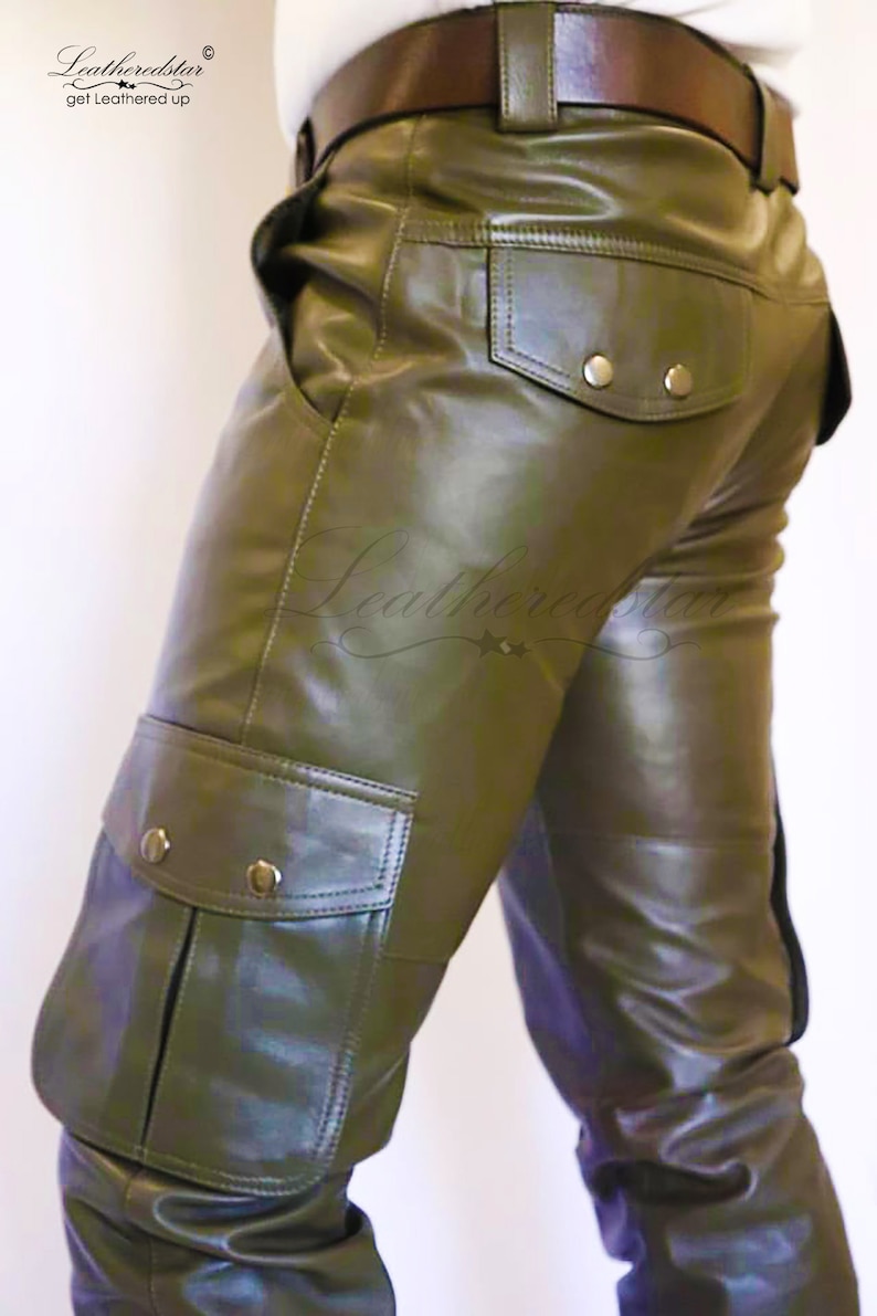May include: Olive green leather cargo pants with a brown leather belt. The pants have a large cargo pocket on the left leg and a smaller pocket on the right back.