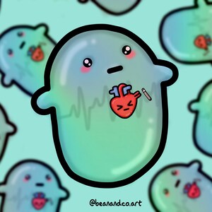 May include: A green cartoon ghost with a sad expression, a red heart with a frown, and a small white stick poking out of its side. The ghost has a faint blue and green gradient and a black outline. The background is a light blue-green colour. The text "@beanandco.art" is at the bottom of the image.