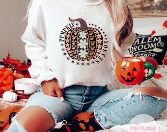 May include: A white sweatshirt with a black pumpkin design featuring a floral pattern and the text "Pumpkin Season".