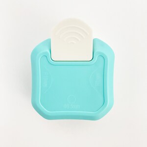 May include: A light blue plastic paper punch with a white lever. The punch has a 0.55mm hole and is labeled "R18mm" and "R10mm".