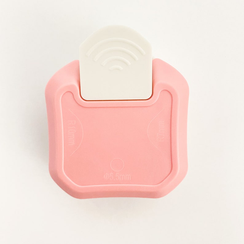 May include: Pink plastic paper punch with a white lever. The punch creates a 0.5 inch circle and has a 1.6 inch diameter.