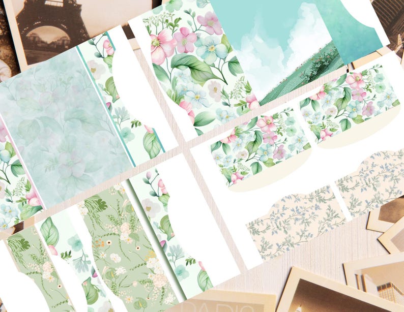May include: A collection of printed paper sheets featuring various floral patterns in shades of pink, light blue, and green. The designs include watercolor-style flowers, leafy foliage, and soft landscape scenes with clouds, presented in multiple rectangular shapes.