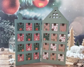 May include: A green wooden advent calendar in the shape of a house, with two doors opening to reveal small drawers. Each drawer is decorated with festive patterns and numbers, ideal for the Christmas countdown. The background features Christmas ornaments and a snowy scene.