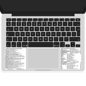 May include: A laptop keyboard with a black frame and silver keys. Two white stickers with text are placed on the keyboard. The stickers contain commands and shortcuts. The keyboard is open and ready for use.