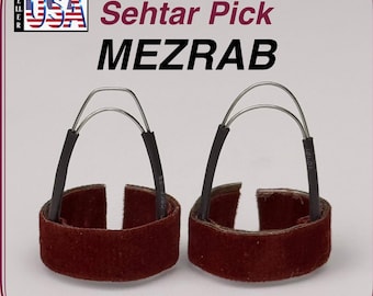 May include: Two Sehtar Pick MEZRAB finger picks. Each pick has a maroon suede band with a black handle and a silver metal loop. The text "Sehtar Pick MEZRAB" is in the image.