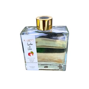 May include: A clear glass bottle with a gold lid filled with a light yellow liquid. The bottle has a white label with the text "KOREFD HOME Lychee & Lotus RELAX DIFFUSER NOTES OF LYCHEE LOTUS FLOWER, SUGAR HANDMADE FLORIDA".