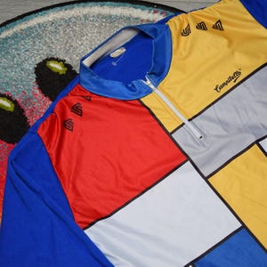 Puede incluir: Un maillot de ciclismo azul, rojo, amarillo, blanco y gris con cremallera y el texto "Campagnolo" en el lado derecho.