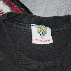 K&ouml;nnte beinhalten: Schwarzes T-Shirt mit einem grafischen Aufdruck. Das Etikett lautet "Kick Start" und "Extra Large".