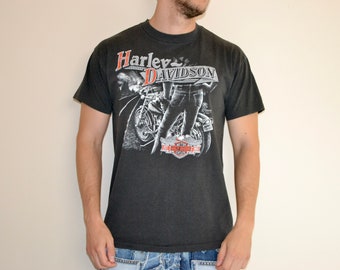 May include: A black t-shirt with a white graphic of a motorcycle and the text "Harley Davidson".