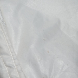 May include: White fabric with a few small brown stains.