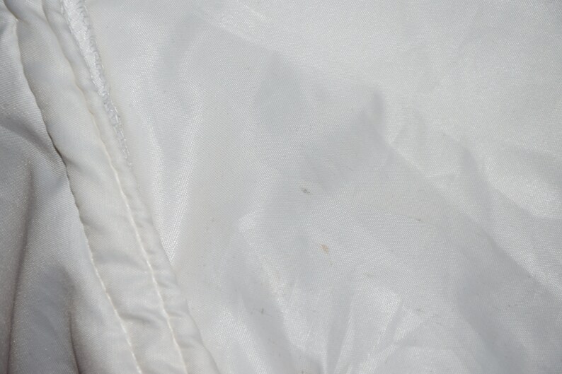 May include: White fabric with a few small brown stains.
