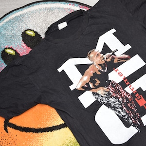 May include: Black t-shirt with a white graphic of a man singing with the word "KILL" in large white letters behind him. The text "you're" is written vertically in red letters on the right side of the graphic.