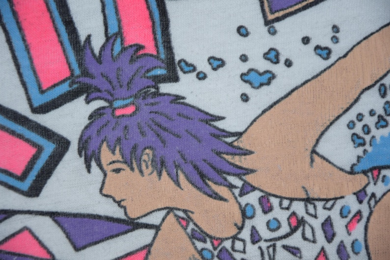 Op de afbeelding: Close-up van een grafische illustratie met een persoon met paars haar in een paardenstaart. De persoon is in profiel afgebeeld, met een lichte huidskleur. De afbeelding heeft een retro-esthetiek, met roze, blauwe en paarse geometrische vormen.