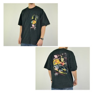 Op de afbeelding: Zwart t-shirt met een afbeelding van een raceauto en coureur met nummer 8. De voorkant toont het Bass Pro Shops-logo en nummer 8. De achterkant heeft een grotere afbeelding van de coureur en auto.