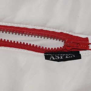 May include: A red zipper with a black label that says "ASPEN" on a white background.