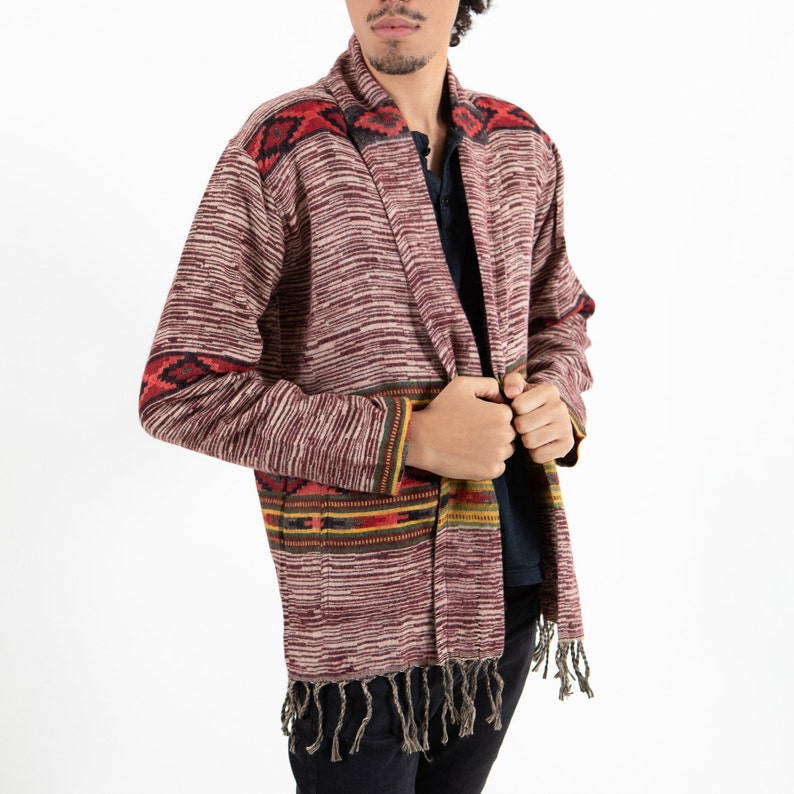 Male model wearing a stylish burgundy cardigan with yellow stripes and fringes on the end.