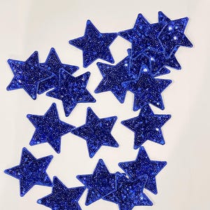 May include: A collection of blue star-shaped patches with a sparkly finish. The patches are made of sequins and are perfect for adding a touch of sparkle to any project.